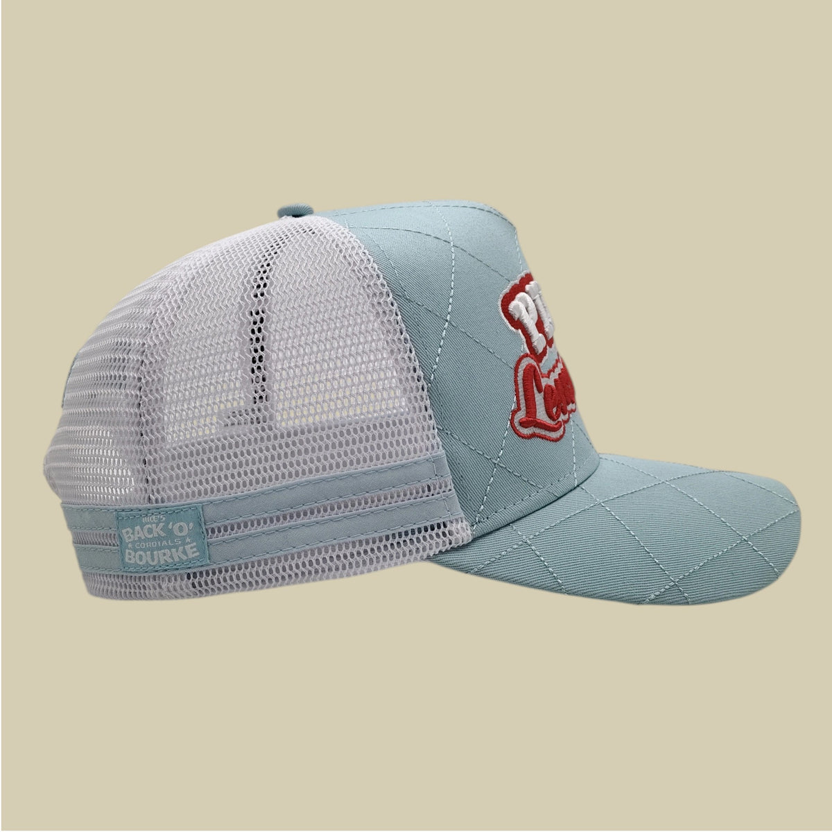 A light blue and white trucker hat with a red embroidered logo on the side, shown against a solid beige background.