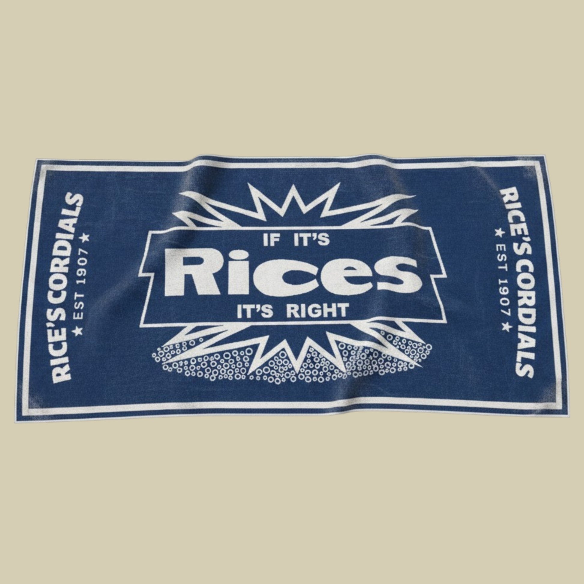 A rectangular navy blue towel featuring a white graphic print of the fictional brand 'Rice's Cordials' with the slogan 'IF IT'S RICES IT'S RIGHT' and decorative starburst patterns, shown flat against a solid beige background.
